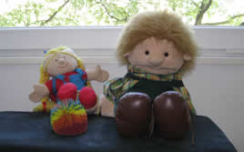 Teddybär und Handpuppe mit blauem Ball auf Holzregal